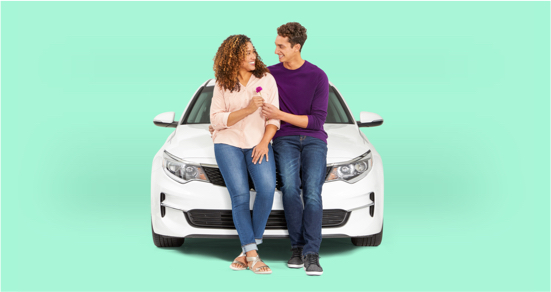 man and woman holding a flower, sitting against the front of a car