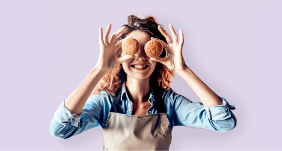 photo of a woman holding muffins up to her eyes